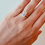 Gold ring with a lab diamond on a hand on a white background