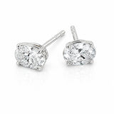 A pair of white gold stud earrings with round brilliant-cut clear diamonds in a four-prong setting, shown on a clean white background.