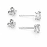 A pair of white gold stud earrings with oval clear diamonds and butterfly backings, displayed on a clean white background.